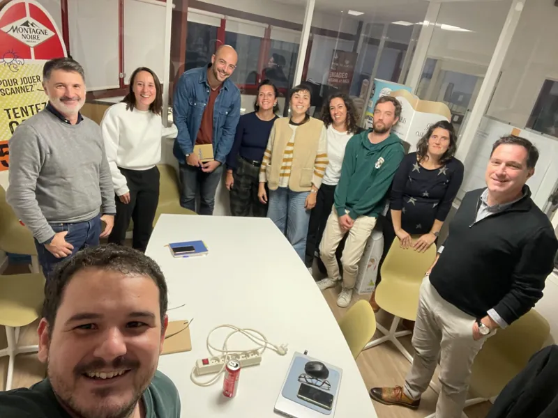 Photo de groupe avec Pierre Saal et les participants dans une salle de réunion.