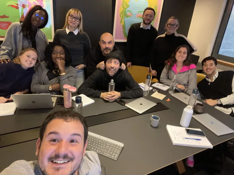 Pierre Saal prend une photo avec un groupe réuni autour d’ordinateurs.